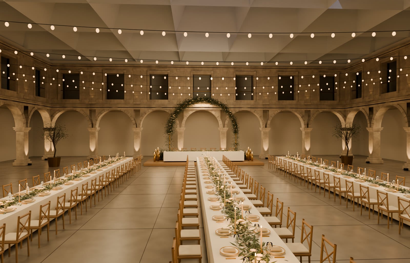 Claustro do Convento do Beato montado para casamento: três mesas imperiais com toalhas de linho, grinaldas de oliveira e velas, luzes de festão e arco de flores atrás da mesa dos noivos